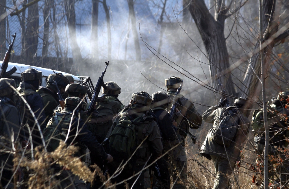 Indian army soldiers take cover near the site of a gun-battle between militants and government forces in Sirnoo Pulwama south of Srinagar on December 15, 2018.  AFP / STR
