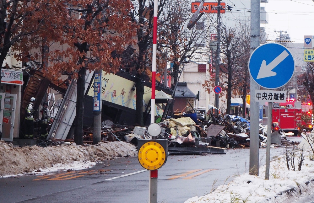 Firefighters inspect the site of an explosion at a restaurant in Sapporo, Hokkaido prefecture on December 17, 2018. Japan OUT / AFP / JIJI PRESS / JIJI PRESS 