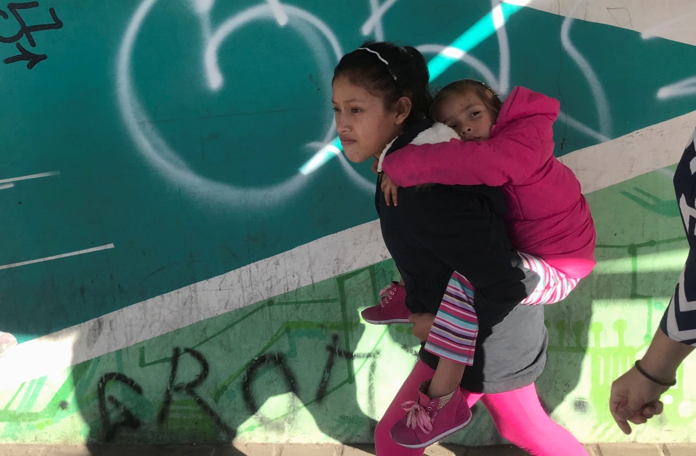Children of Maria Meza, a 40-year-old migrant woman from Honduras, part of a caravan of thousands from Central America trying to reach the United States, on their way to the Otay Mesa port of entry in San Diego to be processed as an asylum seeker, in Tiju