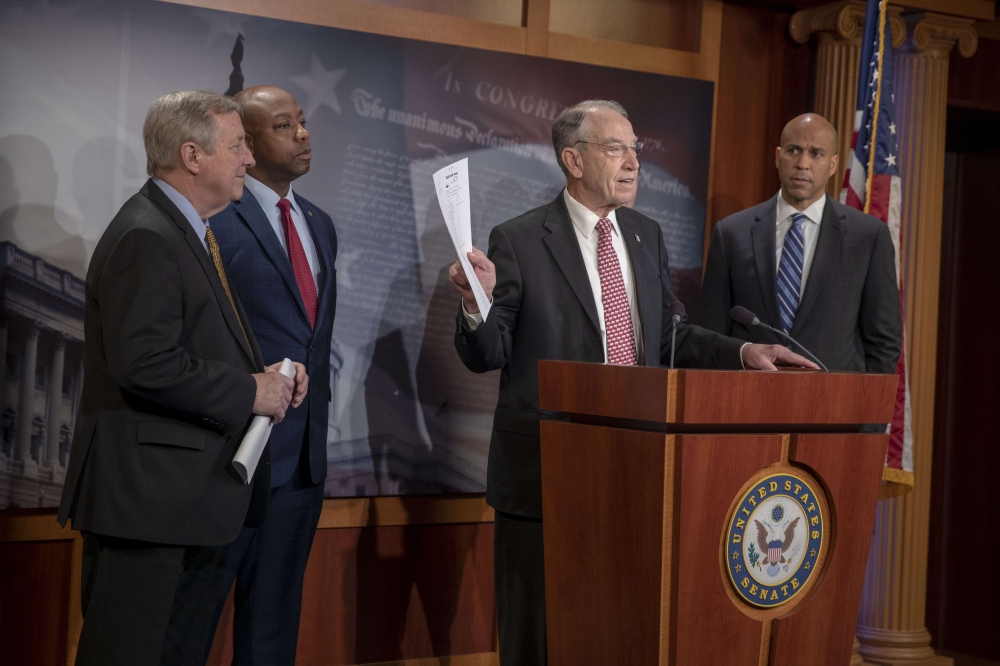 Senator Dick Durbin (D-IL) and Senator Corry Booker (D-NJ) listen to Senate Judiciary Committee Chairman Chuck Grassley (R-IA) speak on the passage of the First Step Act on December 19, 2018 in Washington, DC. Tasos Katopodis/Getty Images/AFP