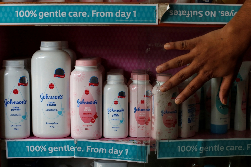 A worker closes a glass cabinet of Johnson & Johnson baby powder bottles at a medical store in Kolkata, India, December 20, 2018. REUTERS/Rupak De Chowdhuri