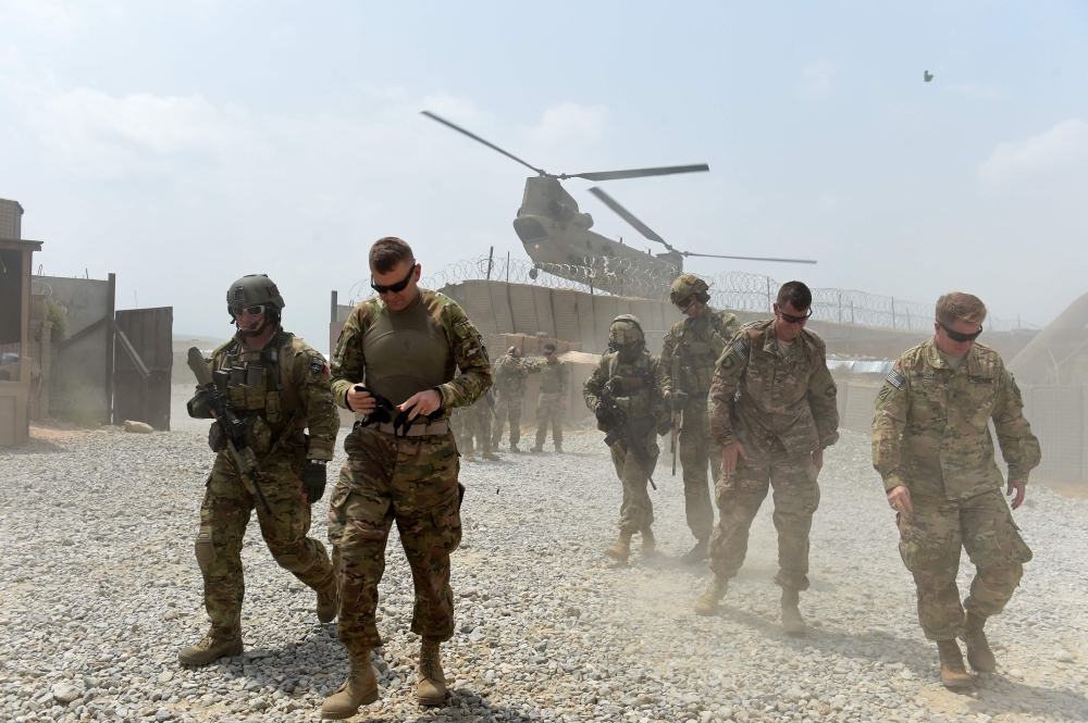 In this file photo taken on August 12, 2015 US army soldiers walk as a NATO helicopter flies overhead at coalition force Forward Operating Base (FOB) Connelly in the Khogyani district in the eastern province of Nangarhar. / AFP / Wakil KOHSAR 