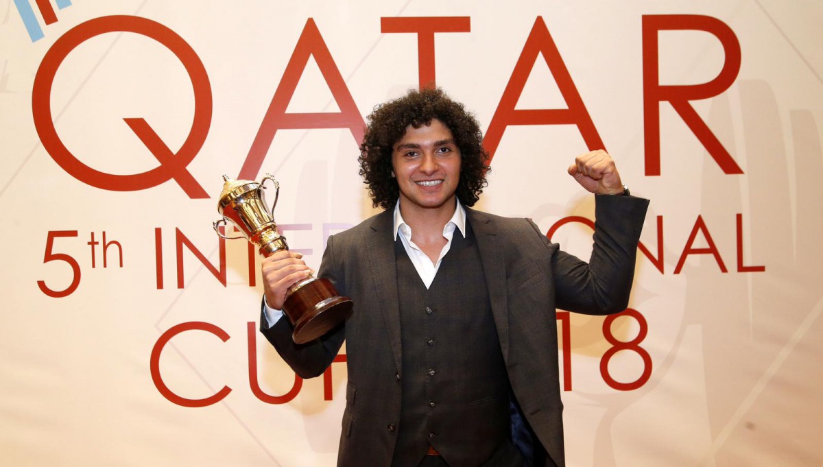 Qatar’s Fares Ibrahim Hassouna celebrates with the top weightlifter’s trophy.