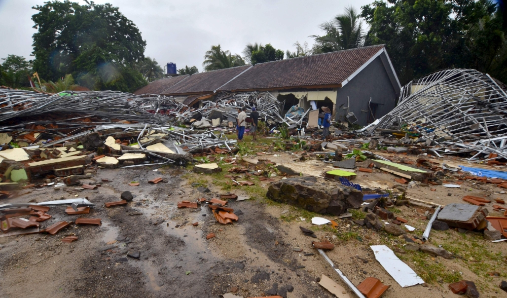 Residents inspect their damaged homes in Carita on December 23, 2018, after the area was hit by a tsunami on December 22 following an eruption of the Anak Krakatoa volcano. / AFP / Ronald 