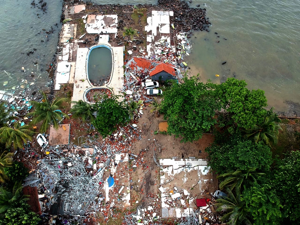 An aerial photo shows damaged buildings in Carita on December 23, 2018, after the area was hit by a tsunami on December 22 following an eruption of the Anak Krakatoa volcano.  AFP / Azwar Ipank
