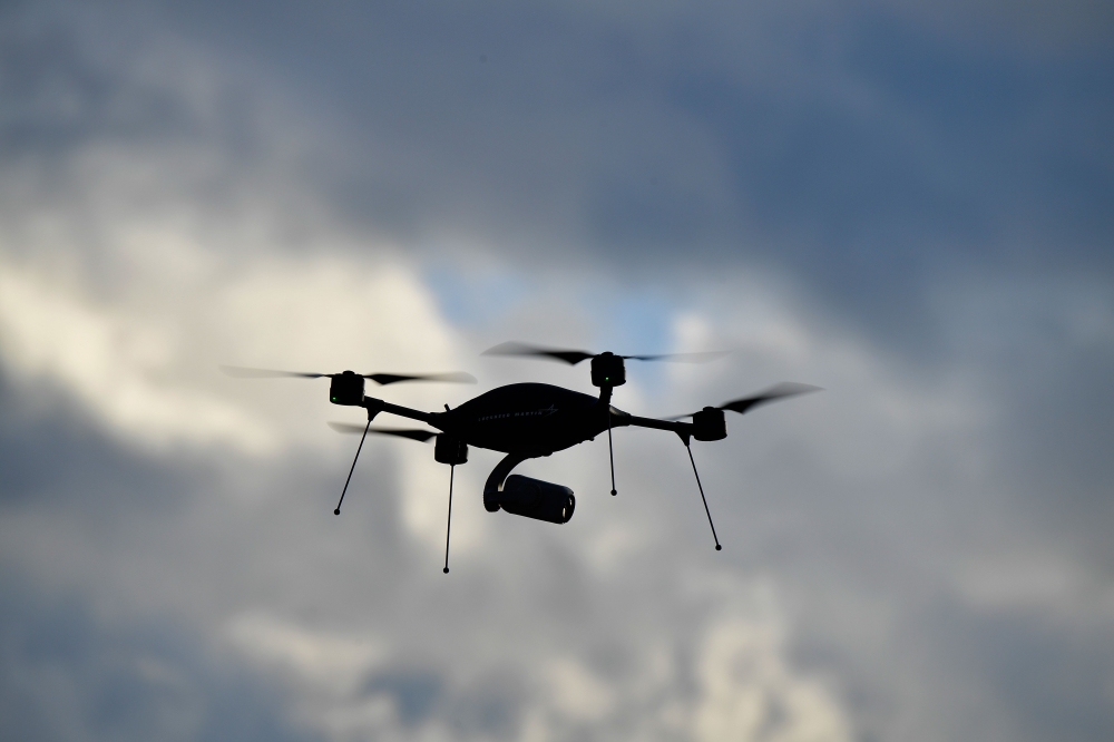 In this file photo taken on December 14, 2017 a surveillance drone silhouettes against the cloudy sky during the handover of 50 new vehicles and equipment to the federal police in Potsdam, eastern Germany. / AFP / Tobias SCHWARZ