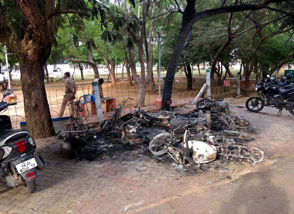 FILE PHOTO: Charred vehicles are pictured near a government office, after at least 13 people were killed when police fired on protesters seeking closure of plant on environmental grounds in town of Thoothukudi in southern state of Tamil Nadu on Tuesday, M