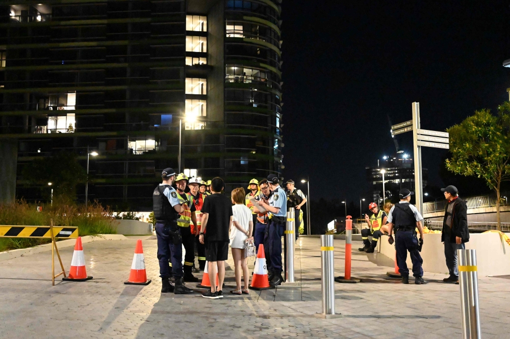 Police check the unit numbers of the residents after an inspection of the Opal Tower by firefighters and engineers in Sydney on December 25, 2018.  / AFP / SAEED KHAN 