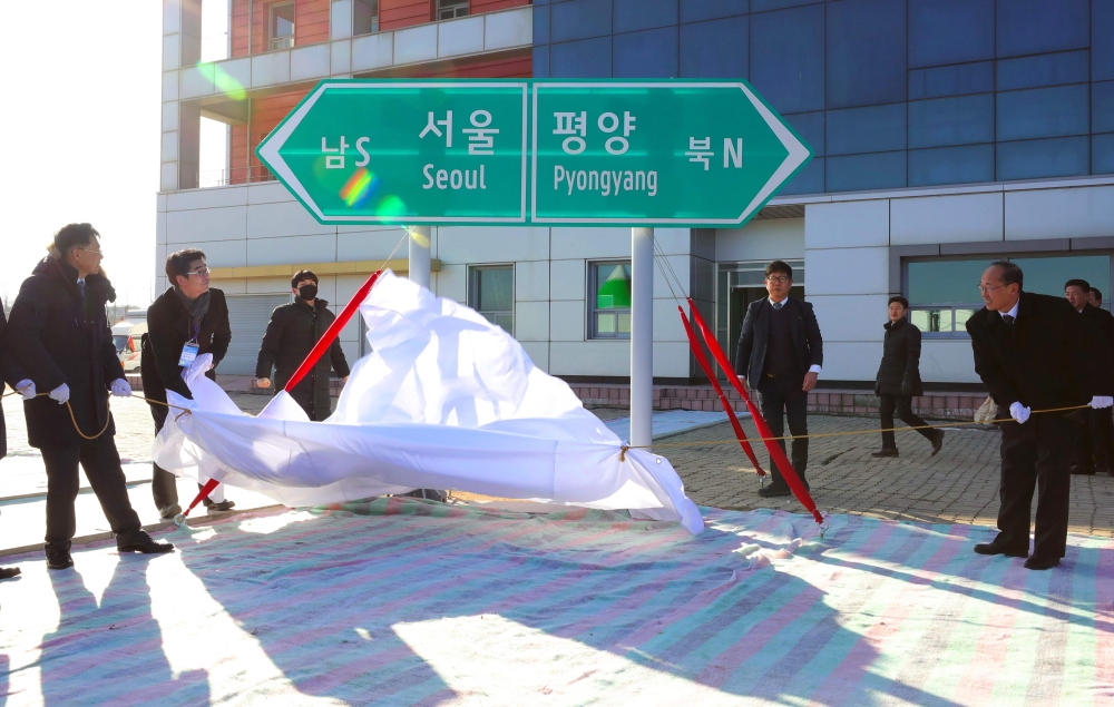 South and North Korean officials unveil a direction signboard for Seoul and Pyongyang during a groundbreaking ceremony for reconnecting and repairing roads and railways across the divided Korean peninsula at Panmun Station in North Korea's border city of 