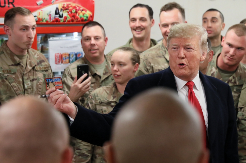 US President Donald Trump holds up a 
