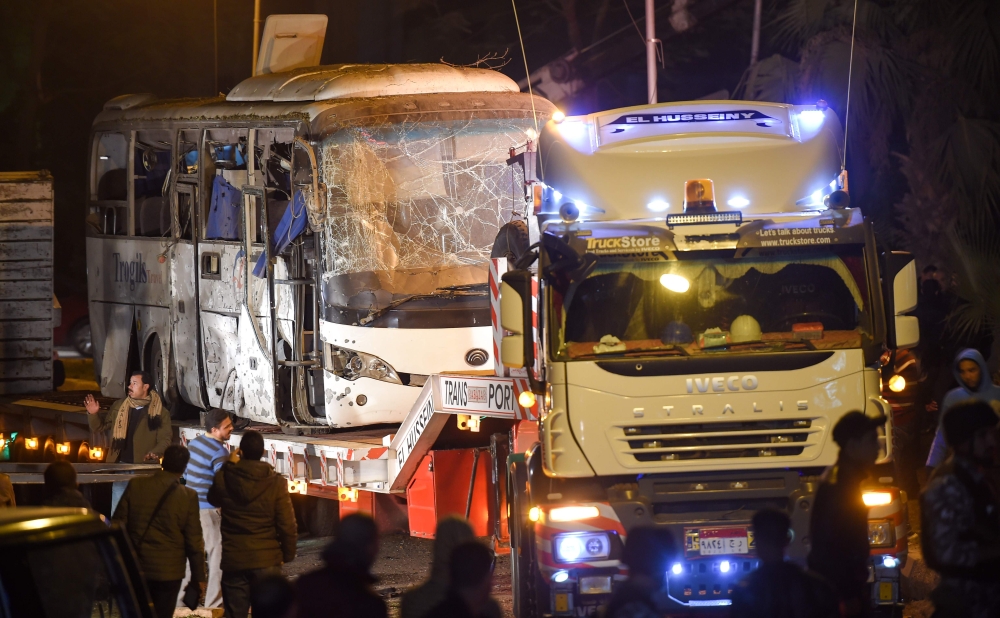This picture taken on December 28, 2018 shows a tourist bus which was attacked being towed away from the scene, in Giza province south of the Egyptian capital Cairo. AFP / MOHAMED EL-SHAHED
