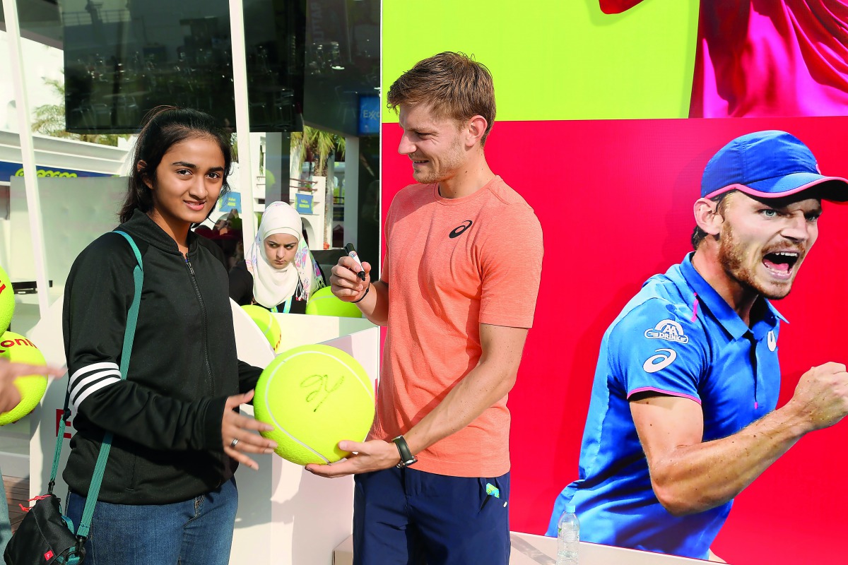 A tennis fan gets an autograph from one of her favourite stars at the Qatar ExxonMobil Open Public Village Stand.