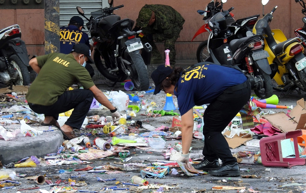 Police officers investigate at the site of an explosion outside a shopping mall in Cotabato City on the southern island of Mindanao on December 31, 2018. AFP 