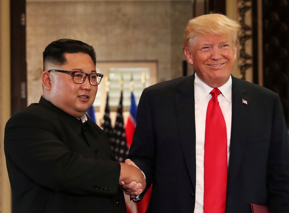 FILE PHOTO: U.S. President Donald Trump and North Korea's leader Kim Jong Un shake hands after signing documents during a summit at the Capella Hotel on the resort island of Sentosa, Singapore June 12, 2018. REUTERS/Jonathan Ernst