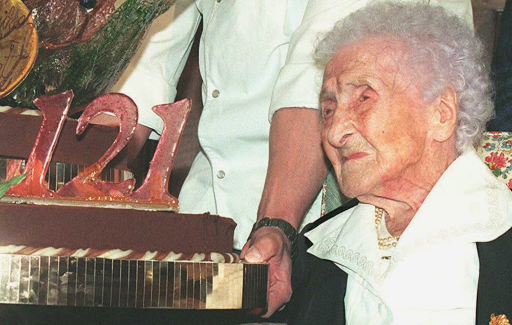 (FILES) In this file photo taken on February 21, 1996, Jeanne Calment, French pensioner and the world's oldest person, looks at her birthday cake upon turning 121 years old during a ceremony held in her honour at Arles City Hall in southern France. AFP / 