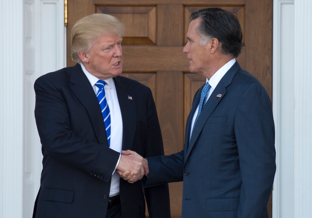 In this file photo taken on November 19, 2016 US President-elect Donald Trump shakes hands with Mitt Romney after their meeting at the clubhouse of Trump National Golf Club in Bedminster, New Jersey. (AFP / Don EMMERT)