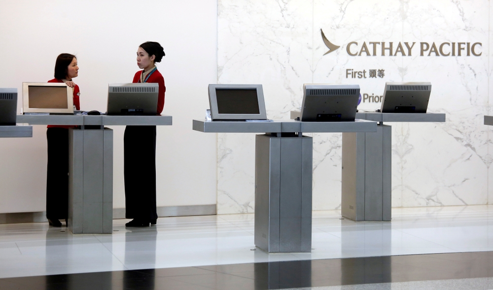 FILE PHOTO: Attendants chat at the First Class counter of Cathay Pacific Airways at Hong Kong Airport in Hong Kong, China April 4, 2018. REUTERS/Bobby Yip/File photo
