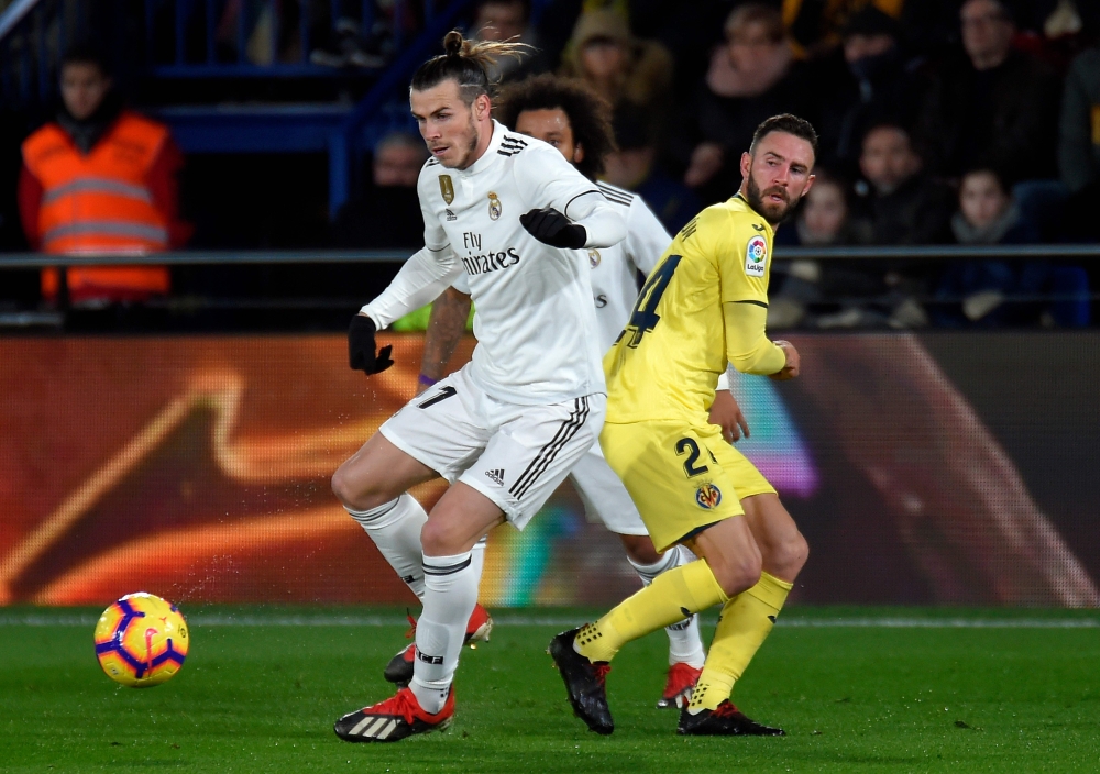 Villarreal's Mexican defender Miguel Layun (R) vies with Real Madrid's Welsh forward Gareth Bale during the Spanish League football match between Villarreal CF and Real Madrid CF at La Ceramica stadium in Vila-real on January 3, 2019. / AFP / JOSE JORDAN
