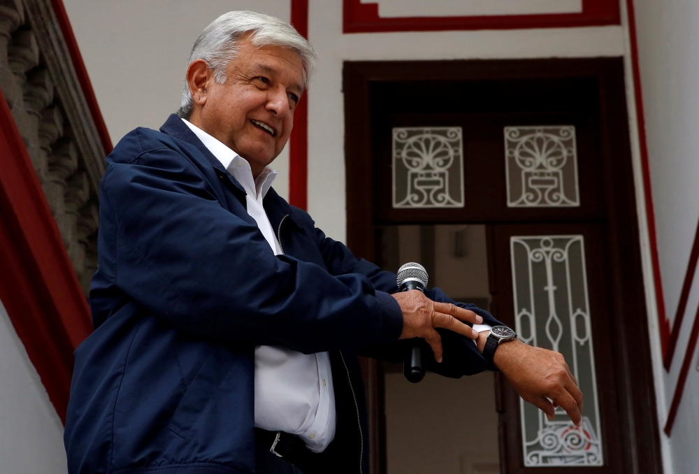 FILE PHOTO: Mexico's president-elect Andres Manuel Lopez Obrador shows his watch following a question by a reporter after a news conference in Mexico City, Mexico July 22, 2018. REUTERS/Ginnette Riquelme/File Photo