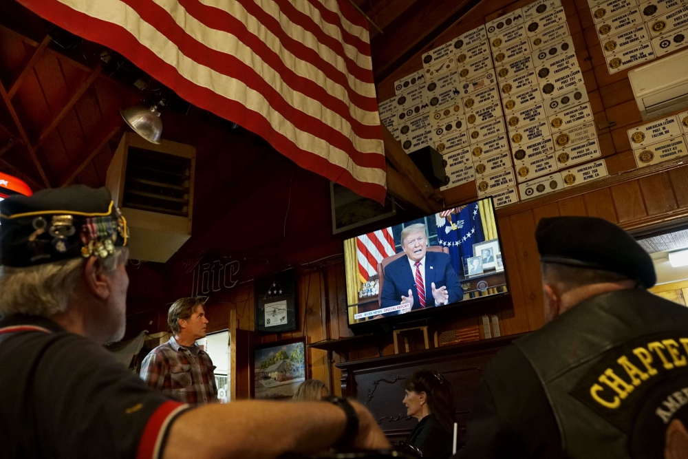 Members of American Legion Post 416 watch President Donald Trump speak on January 8, 2019 in Encinitas, California. The president spoke in his first prime-time address from the Oval Office in an effort to build support for $5.7 billion in funding for a bo