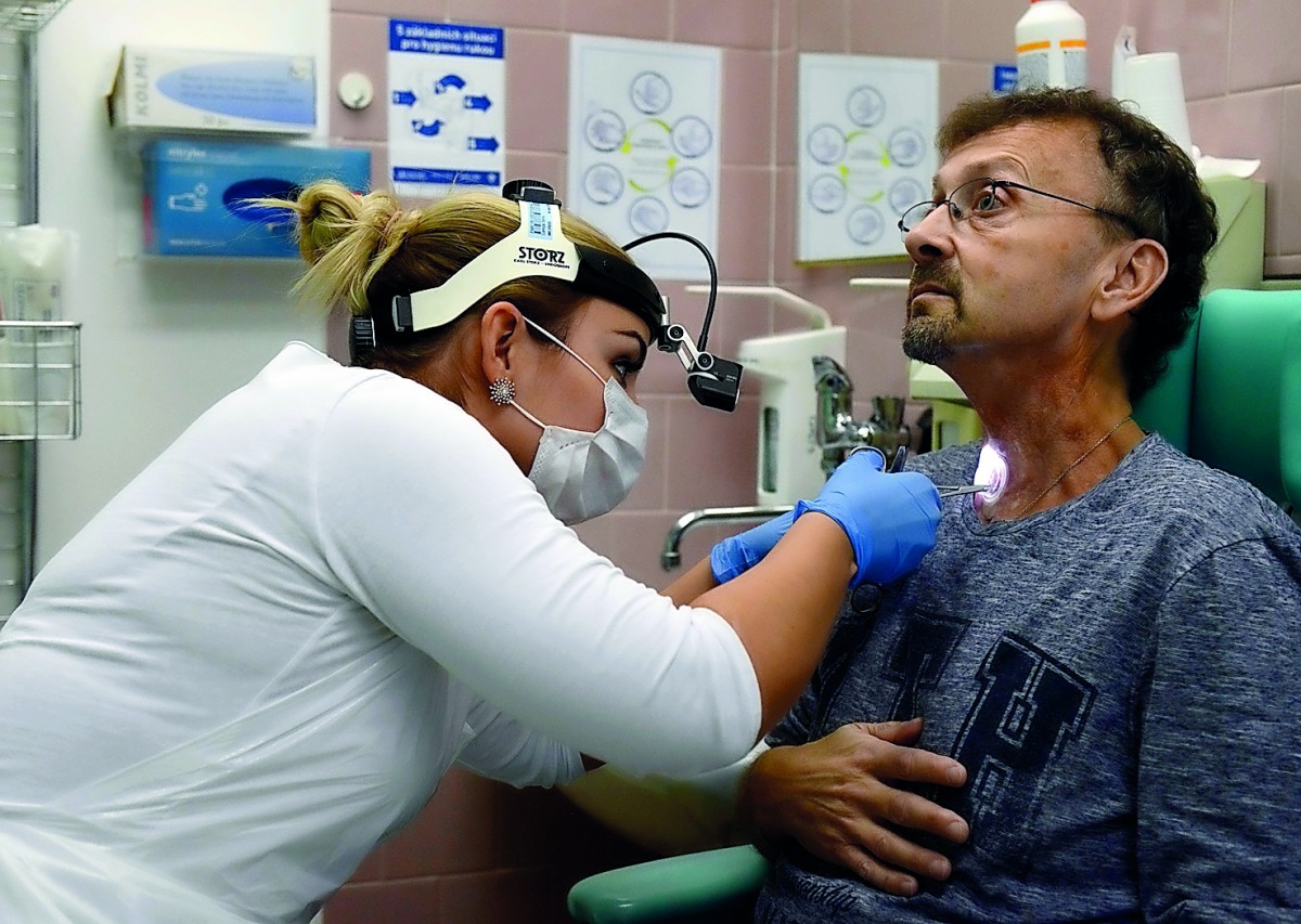 Czech doctor Barbora Repova, who leads the project of a new hi-tech voice app on behalf of Charles University, inspects a hole in the throat of her patient, Martin Kozel, on December 07, 2018 at Motol hospital, in Prague. AFP / Michal Cizek
