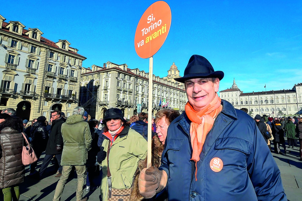 A man holds a sign reading 