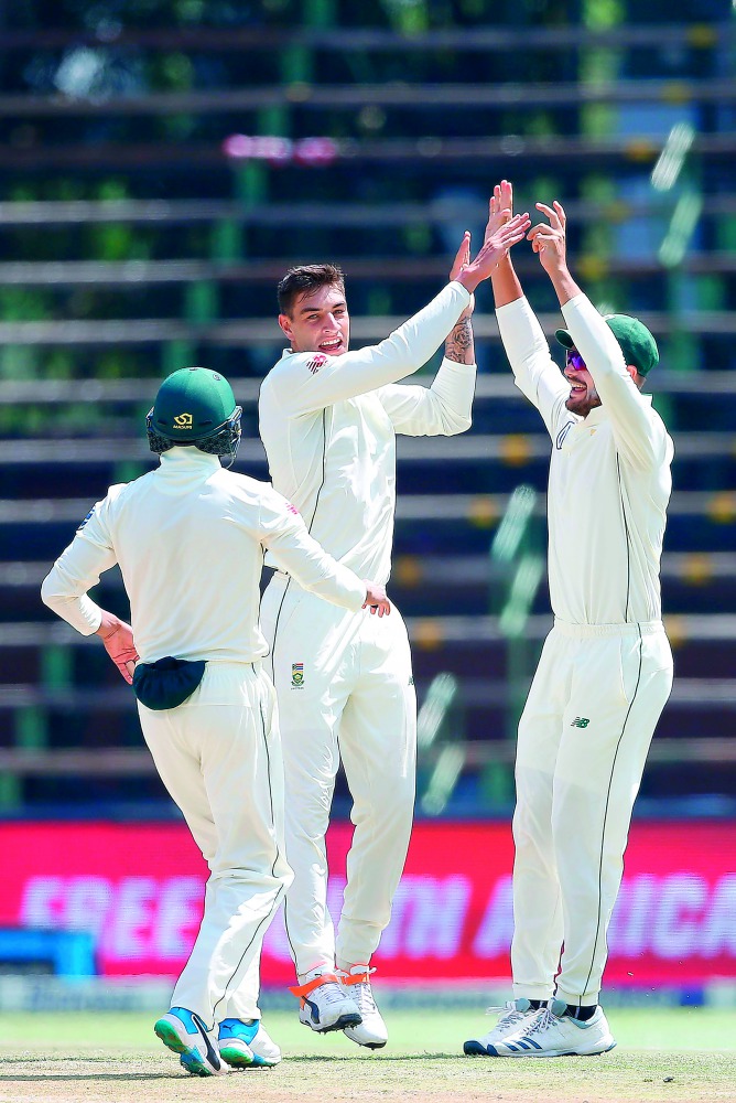 South African bowler Duanne Olivier (C) celebrates the dismissal of Pakistan batsman Sarfraz Ahmed (not in picture) during the fourth day of the third Cricket Test match between South Africa and Pakistan at Wanderers cricket stadium on January 14, 2019 in