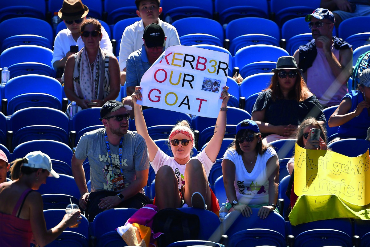 A spectator holds up a placard during the women's singles match between Germany's Angelique Kerber and Slovenia's Polona Hercog on day one of the Australian Open tennis tournament in Melbourne on January 14, 2019. AFP / William West