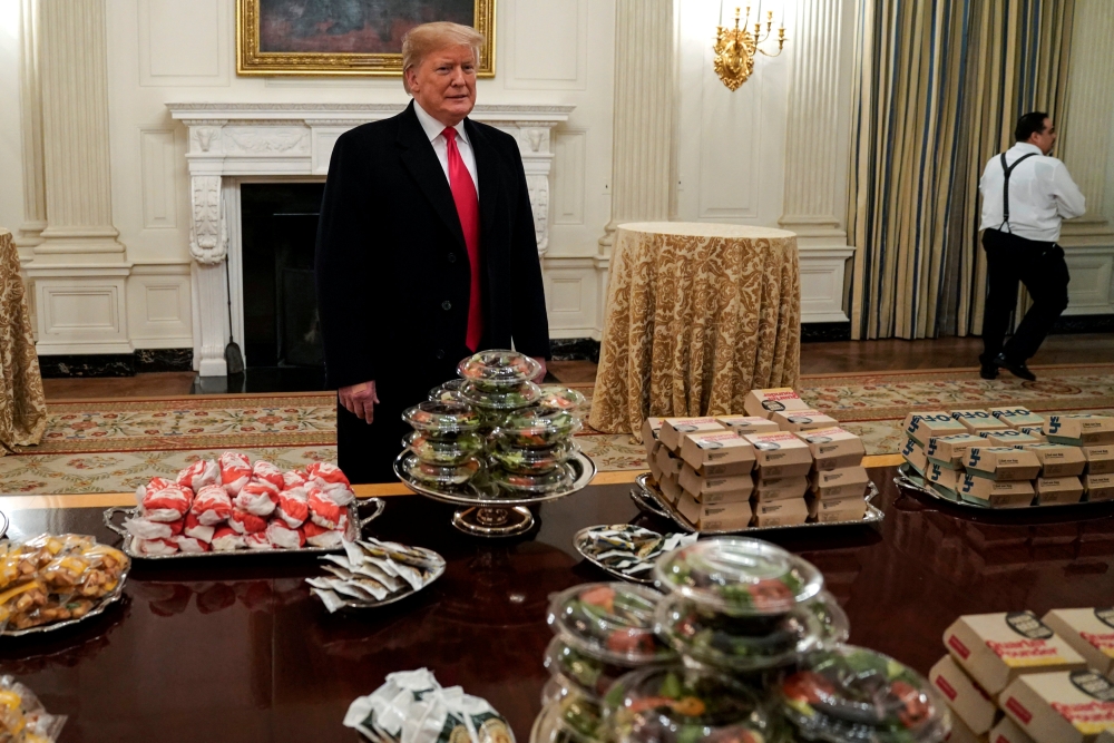 US President Donald Trump speaks in front of fast food provided for the 2018 College Football Playoff National Champion Clemson Tigers due to the partial government shutdown in the State Dining Room of the White House in Washington, U.S., January 14, 2019