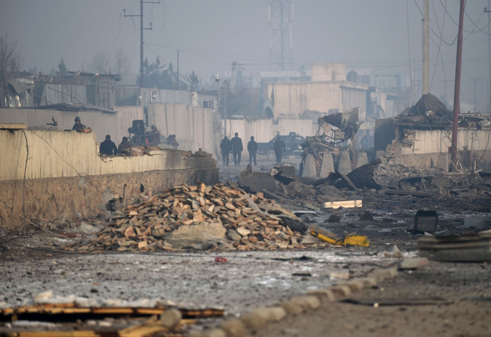 Afghan security forces gather at the site of a powerful truck bomb attack a day after it detonated near a foreign compound in Kabul on January 15, 2019. AFP / WAKIL KOHSAR
 