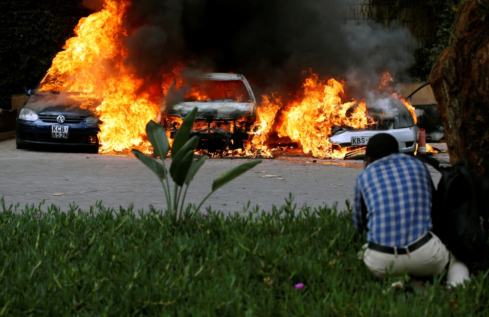 Cars are seen on fire at the scene of explosions and gunshots in Nairobi, Kenya January 15, 2019. REUTERS/Thomas Mukoya