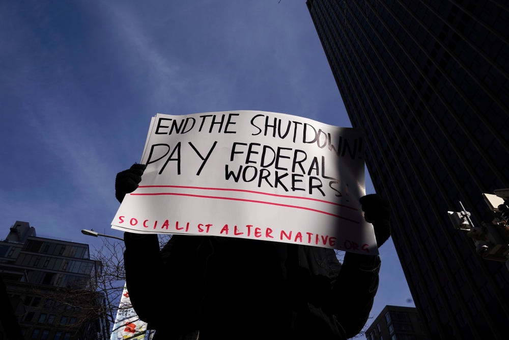 A protestor holds a sign during a rally outside a closed federal building in the Manhattan borough of New York City, New York, U.S., January 15, 2019. REUTERS/Carlo Allegri