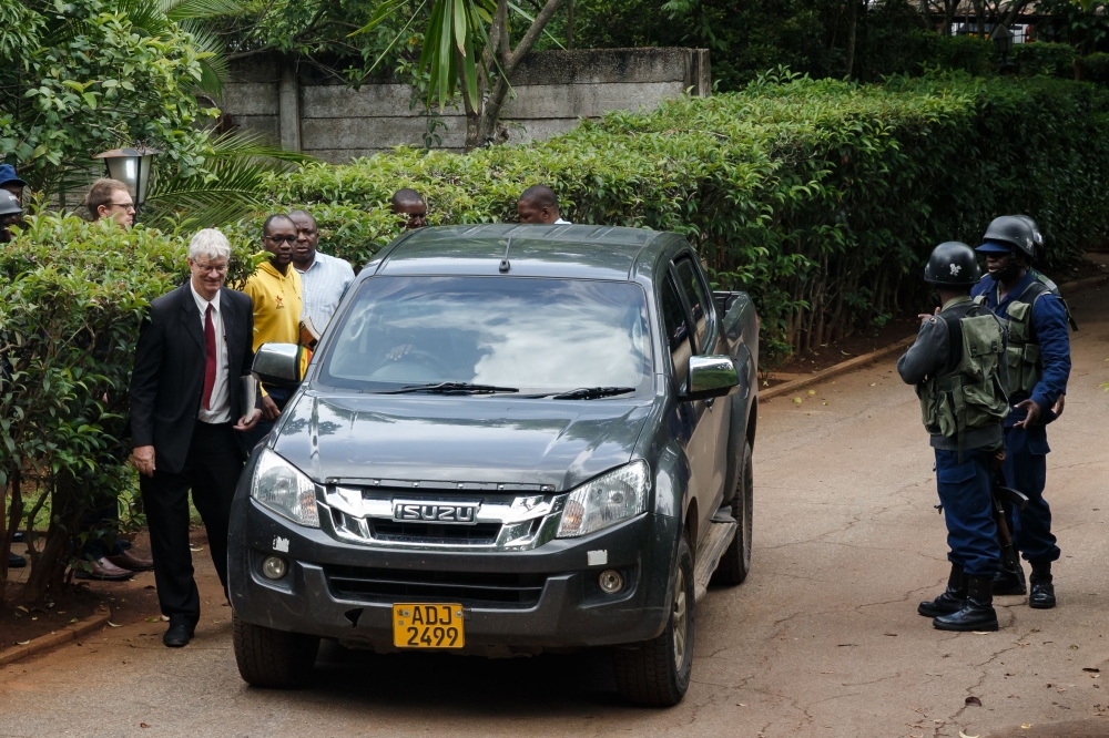 Zimbabwean cleric and activist Evan Mawarire (2nd L) is escorted to a car by Zimbabwean policemen on January 16, 2019, after he was picked up from his home in Avondale, Harare.   AFP / Jekesai NJIKIZANA