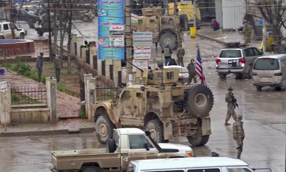 An image grab taken from a video obtained by AFPTV on January 16, 2019, shows US troops gathered at the scene of a suicide attack in the northern Syrian town of Manbij. AFP / ANHA 