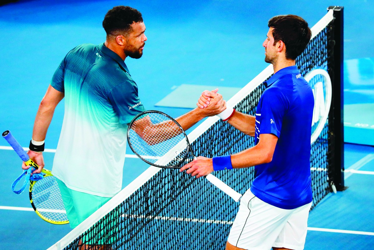 Serbia's Novak Djokovic (R) shakes hand with France's Jo-Wilfried Tsonga after their men's singles match on day four of the Australian Open tennis tournament in Melbourne early January 18, 2019. AFP / David Gray