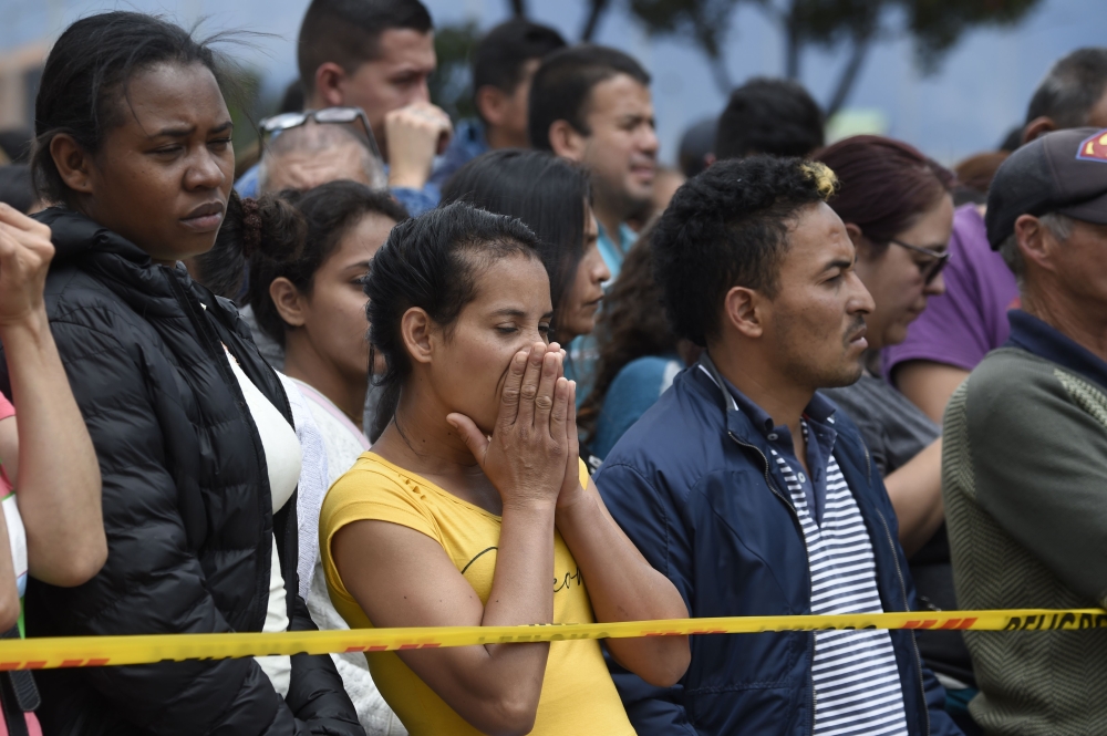 People wait for news outside the site of an explosion on a police cadet training school in Bogota on January 17, 2019. AFP / Juan Barreto
 