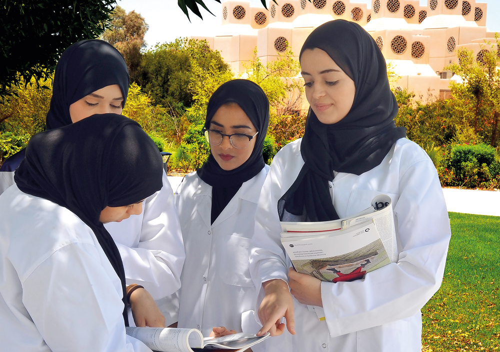 Public Health students discussing a point at Qatar University campus. RIGHT: A professor guiding a student doing a lab test.