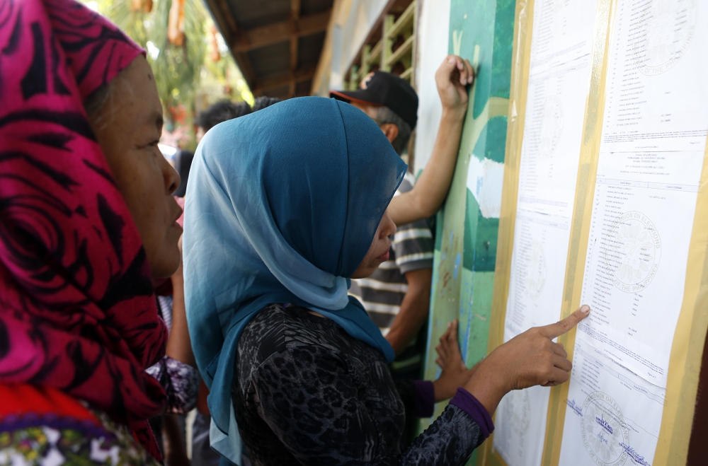Residents look for their names at the list at Simuay Junction Central Elementary School, to cast their votes during the referendum in Sultan Kudarat town of Maguindanao province in Philippines on January 21, 2019.(Jeoffrey Maitem/Anadolu Agency)