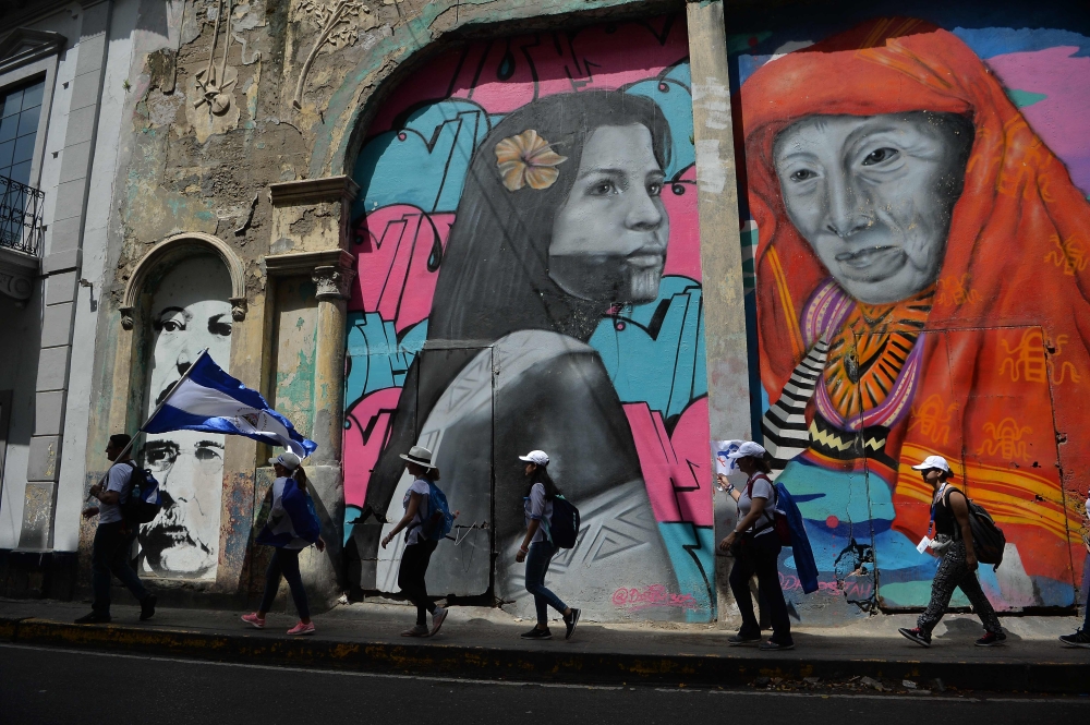 Pilgrims walks with a Nicaraguan flag through the streets of Panama City during World Youth Day on January 24, 2019. AFP / Marvin Recinos 