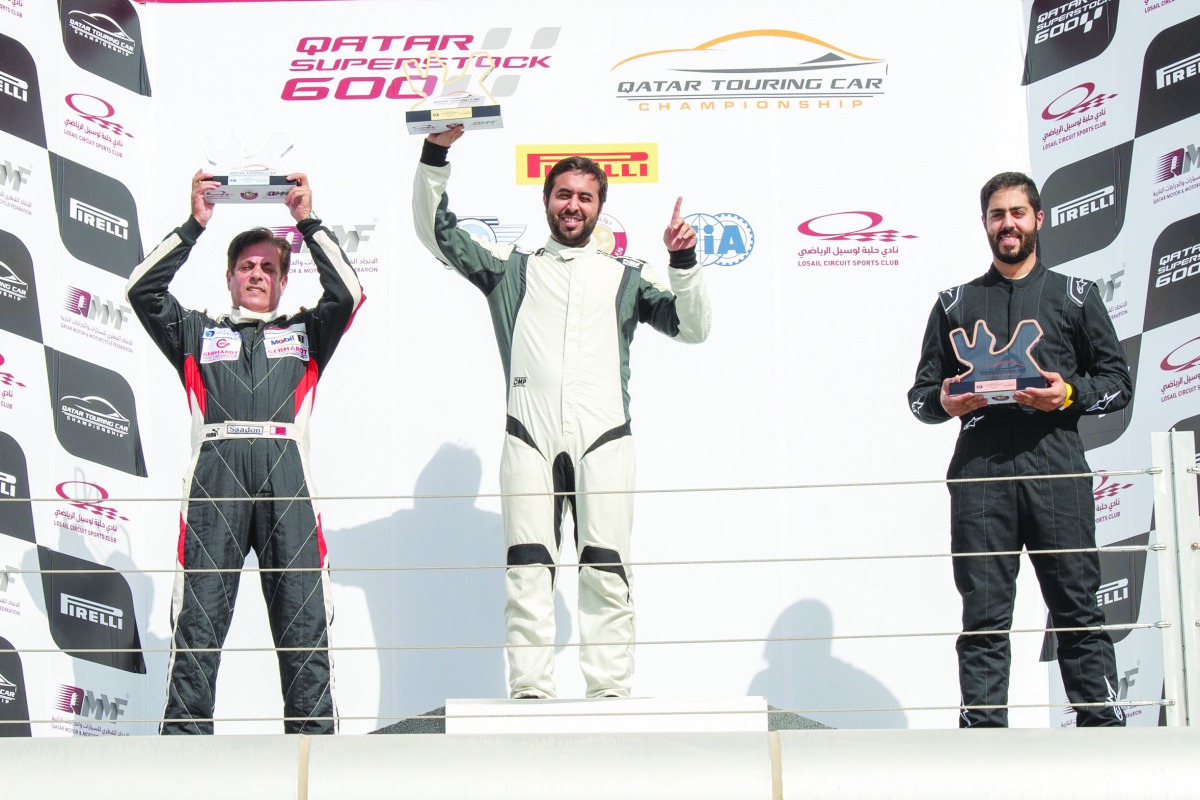 Qatar’s Abdulla Al Khelaifi (centre), Saadon Al Kuwari and Ibrahim Al Abdulghani pose on the podium after a Qatar Touring Car Championship race at Losail International Circuit yesterday.   
