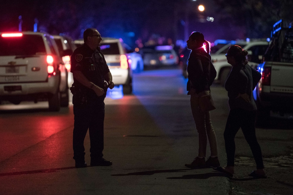 An officer assists local residents trying to get to their homes near the scene of a shooting where five Houston police officers were reported shot January 28, 2019 in Houston, Texas. Loren Elliott/Getty Images/AFP