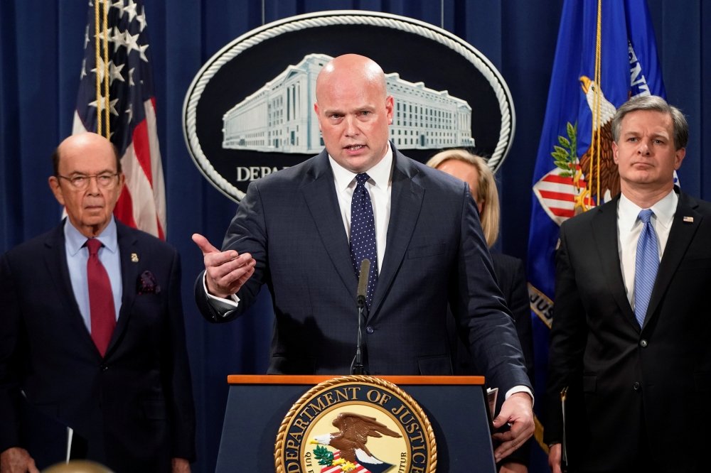 Acting Attorney General Matthew Whitaker speaks flanked by U.S. Commerce Secretary Wilbur Ross (L) and FBI Director Christopher Wray (R) during a news conference to announce indictments against China's Huawei Technologies Co Ltd, several of its subsidiari