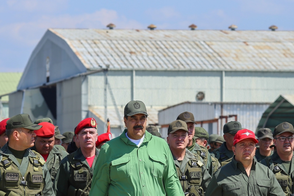 This handout picture released by the Venezuelan presidency shows Venezuela's President Nicolas Maduro (C) and Defence Minister Vladimir Padrino (L) taking part in a ceremony during military exercises at the Libertador Air Base in Maracay, Aragua state, Ve
