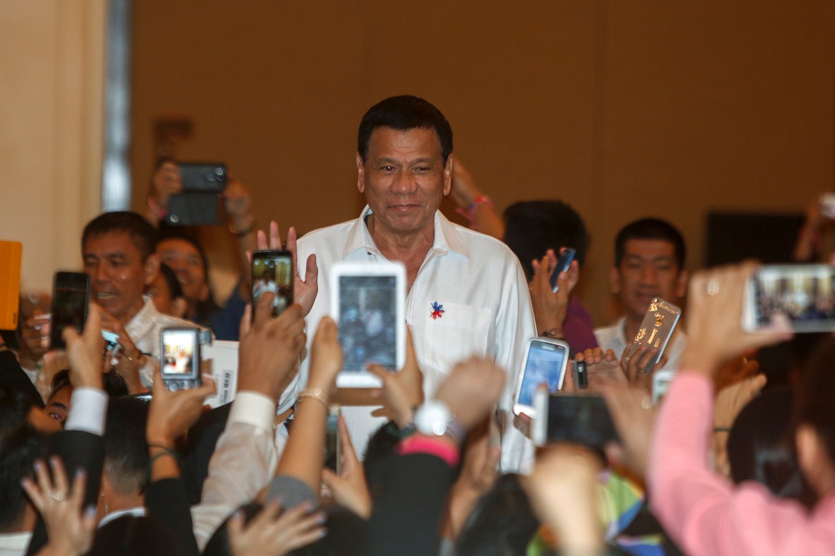FILE PHOTO: Philippine President Rodrigo Duterte greets people before a meeting with the Filipino Community at a hotel in Phnom Penh, December 13, 2016. Reuters/Samrang Pring