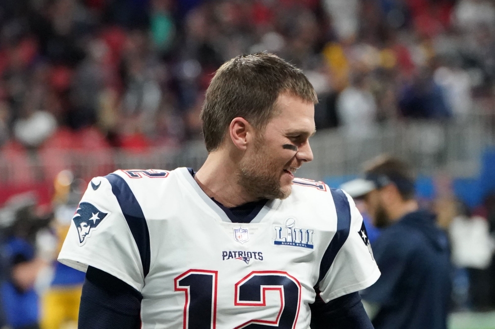 Quarterback for the New England Patriots Tom Brady (12) speaks with running back for the New England Patriots James White (out of frame) before the Super Bowl LIII between the New England Patriots and the Los Angeles Rams at Mercedes-Benz Stadium in Atlan