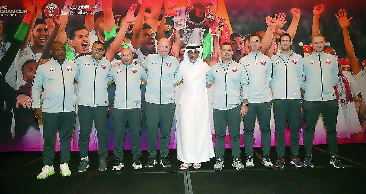 The QFA President poses for a photograph with the support staff of Qatar national team.