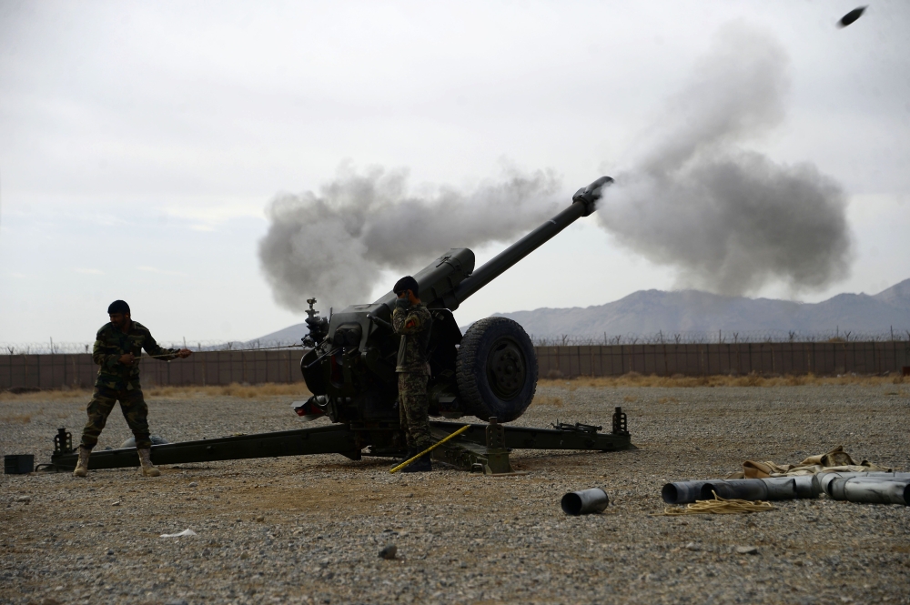 In this photo taken on February 2, 2019, an Afghan National Army (ANA) soldier fire a D30 122mm Howitzer gun as members of the NATO military forces (unseen) look on during a training session of ANA soldiers at Arena base in the Guzara district of Herat pr
