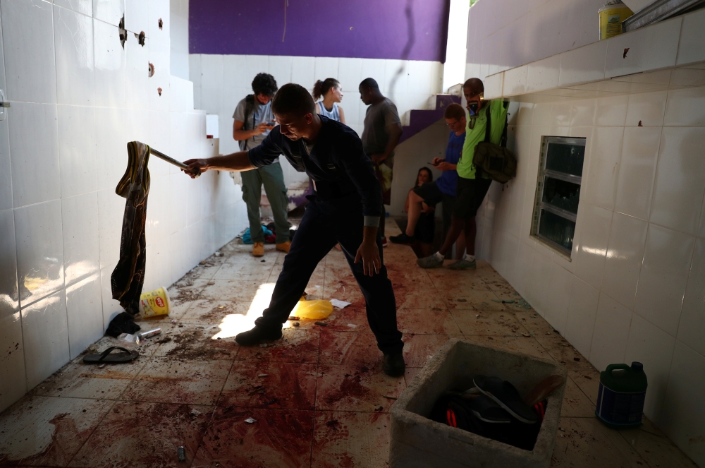A police forensic expert checks a cloth on a blood-stained floor at a house where police officers confronted suspects during an operation against drug gangs at Fallet slum in Rio de Janeiro, Brazil February 8, 2019. Reuters/Pilar Olivares