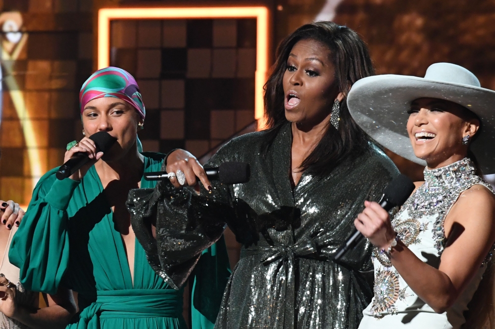 (L-R) Host US singer-songwriter Alicia Keys, former US First Lady Michelle Obama and US singer Jennifer Lopez speak on stage during the 61st Annual Grammy Awards on February 10, 2019, in Los Angeles. / AFP / Robyn Beck
