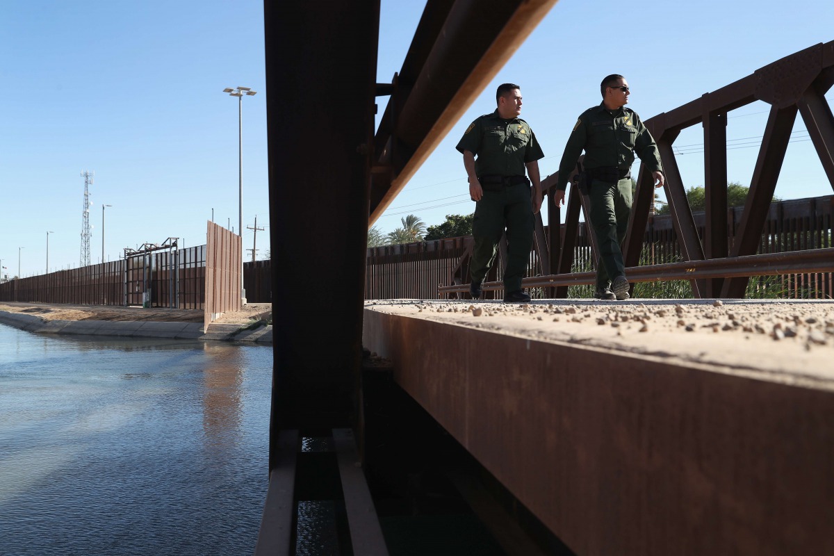 US Border Patrol agents walk over a canal of water flowing into Mexico at the US Mexico border fence on November 17, 2016 in San Luis, Arizona John Moore / Getty Images / AFP